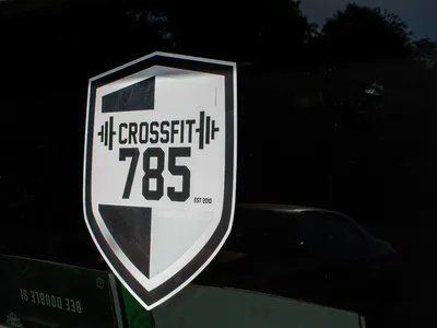The CrossFit 785 shield decal on the glass front door of the building the club trains in.