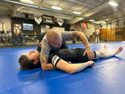 A member holding side control while their partner works to escape.