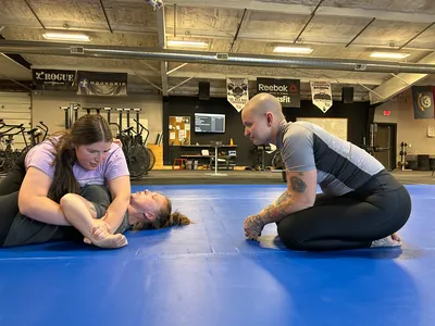 Members of the Women&rsquo;s BJJ class working in pairs across the mat.