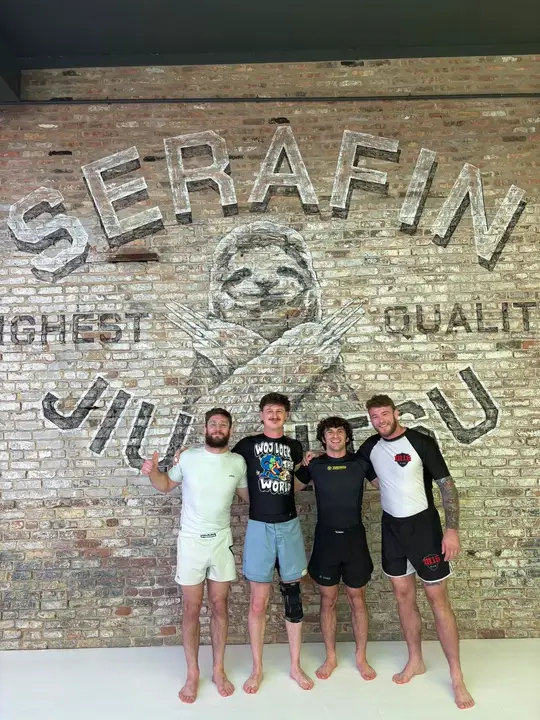 Coach Hunter, second from left, with Chris Wojcik, Keith Krikorian and Declan Moody in front of the Serafin Jiu-Jitsu mural.